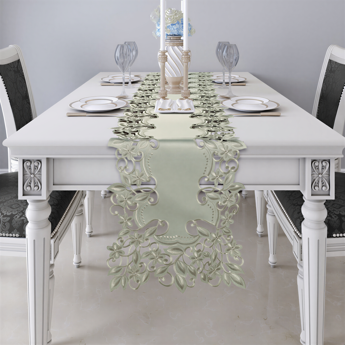 a white dining table set with a floral table runner, plates, and wine glasses.