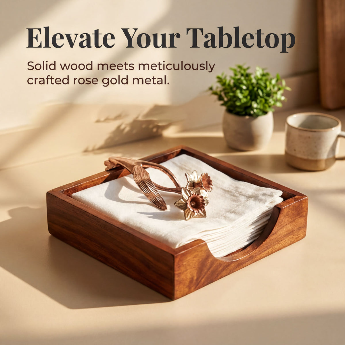 a wooden tissue holder with a white napkin inside, placed on a wooden surface. The tissue holder has a decorative metal flower on top, and there is a small potted plant nearby.