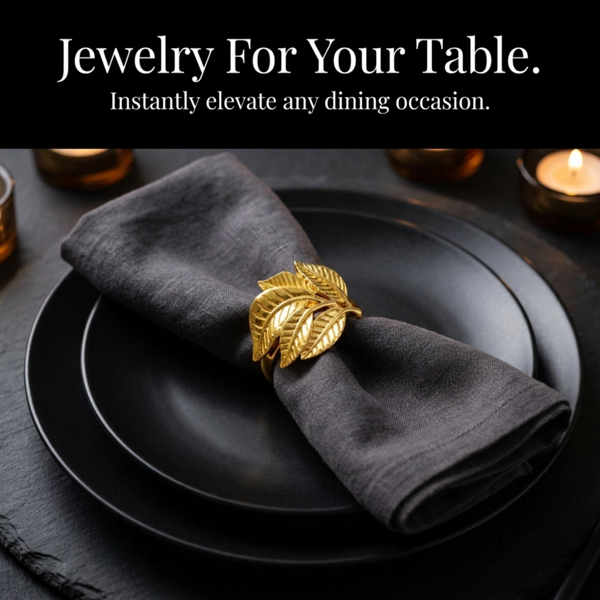 A black plate with a gold leaf-shaped napkin ring on it, placed on a table with candles in the background.