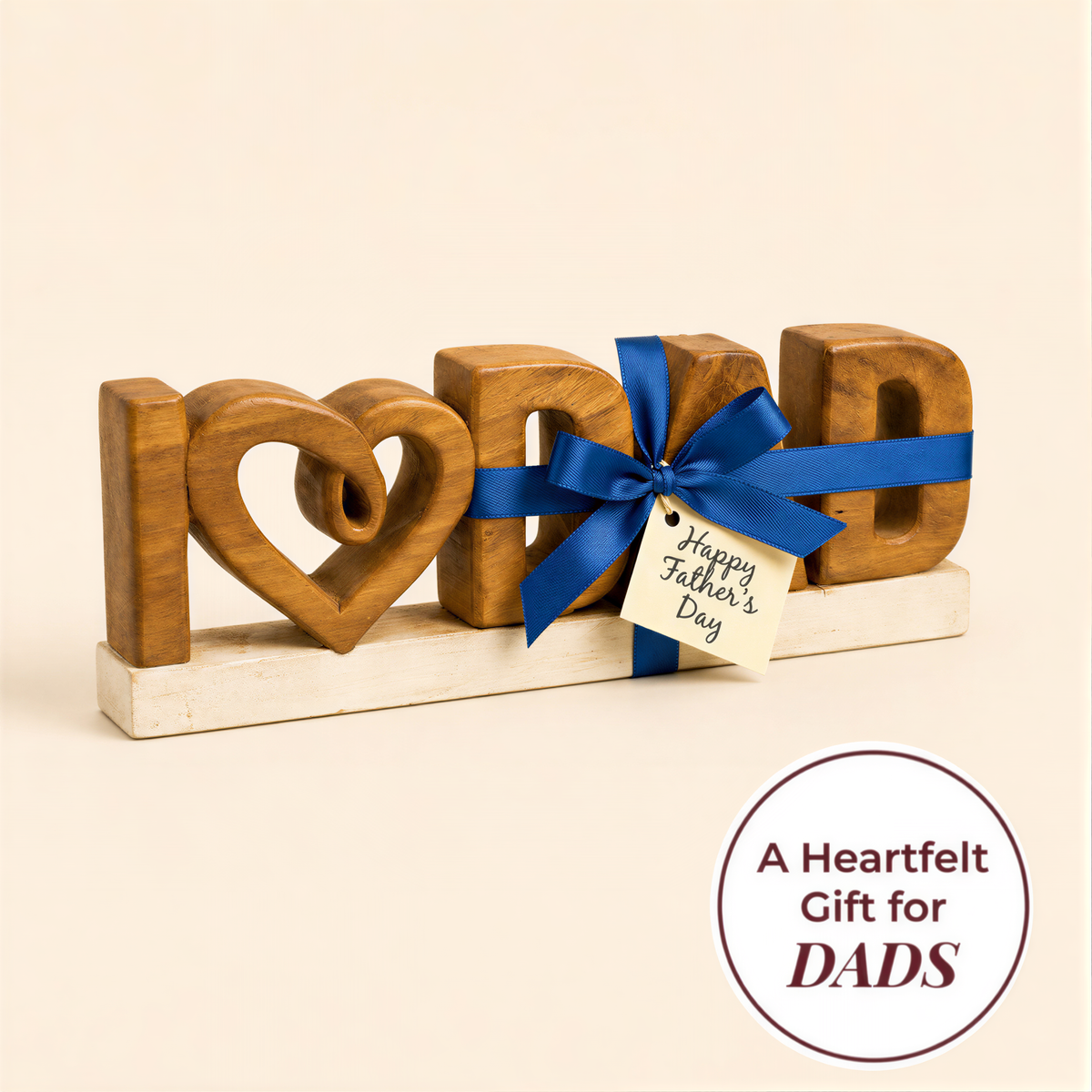 A wooden sign with the word "I" in a heart shape, followed by a blue ribbon and a tag that reads "Happy Father's Day".