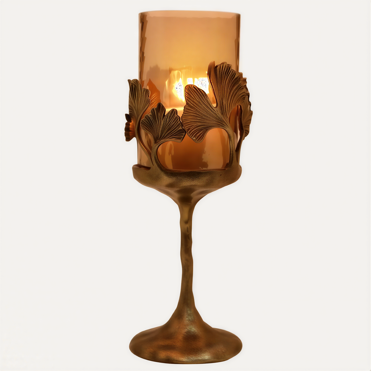 Gold finished candle holder with glass insert, showcasing elegant design for decorative candle display.