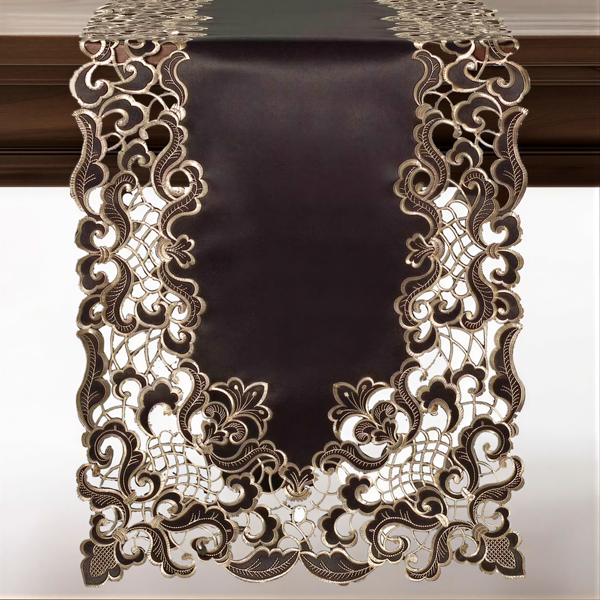 an ornate, dark-colored table runner with intricate gold embroidery. The runner is displayed on a wooden surface, and the background is a plain white wall.