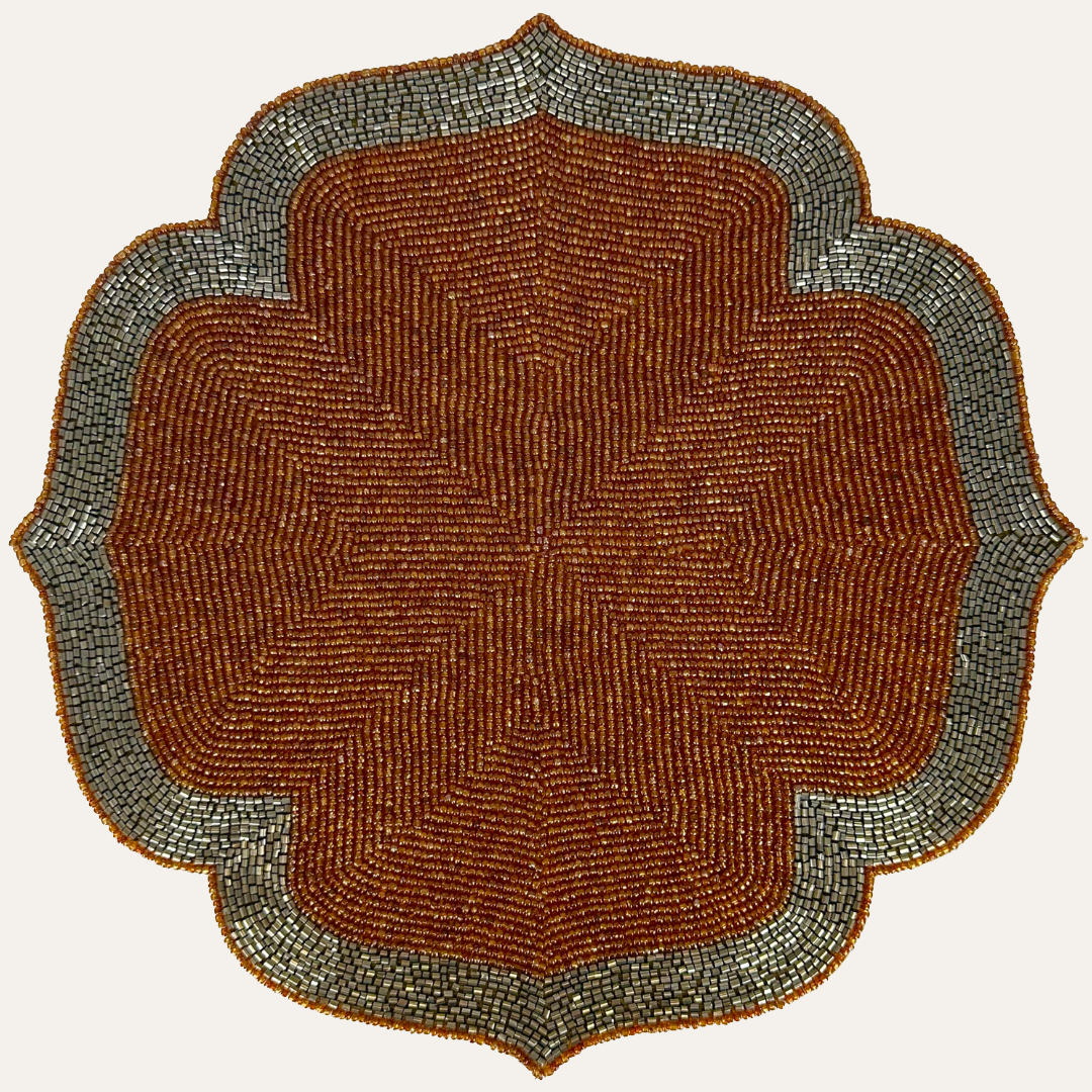 Set of two Sunset Frost beaded placemats in burnt orange and silver, embroidered with intricate beading, 14-inch decorative dining accents.