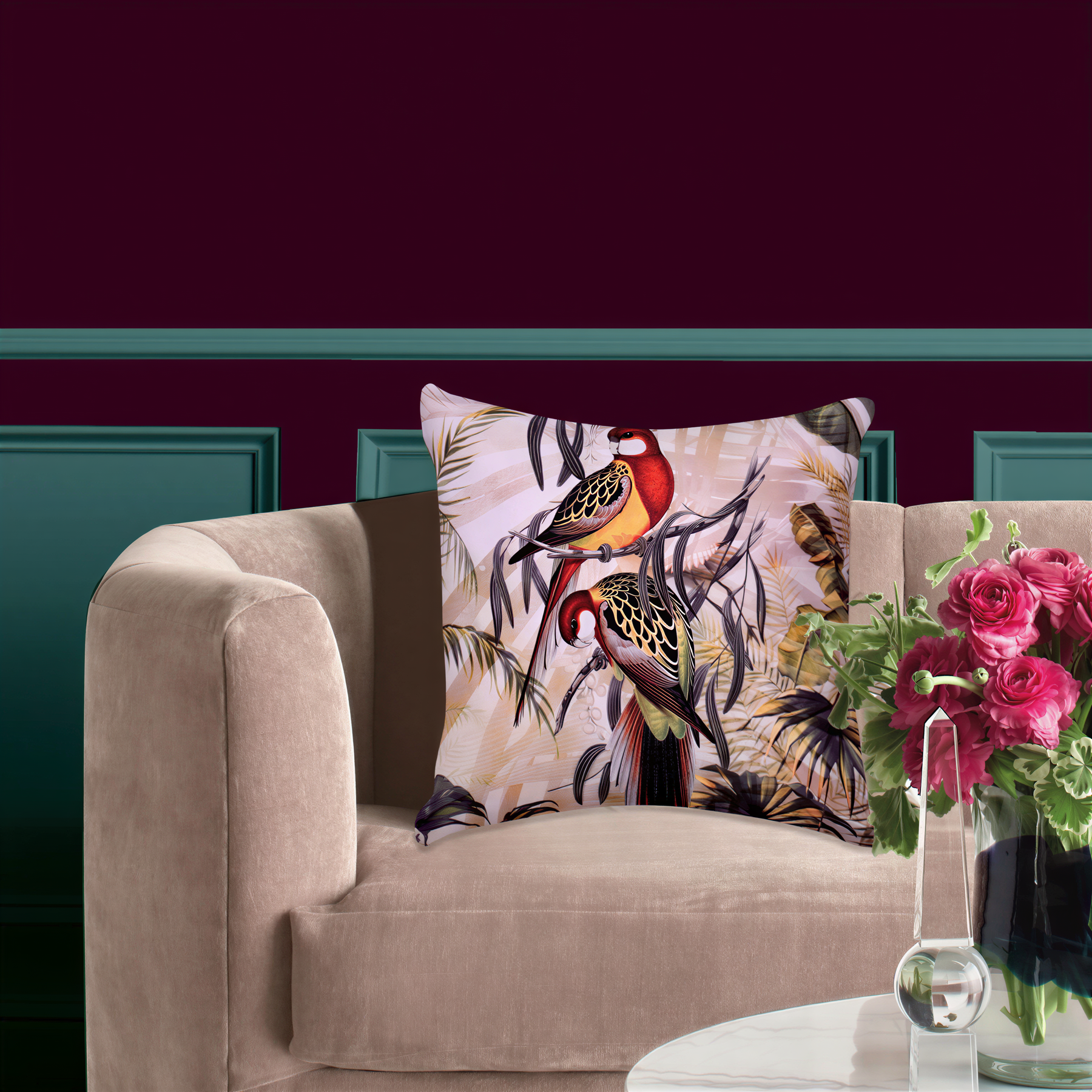 a beige sofa with a decorative pillow featuring a colorful bird design, and a vase of pink flowers placed on a white coffee table in the background.