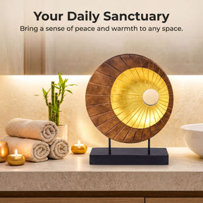 a serene and calming bathroom scene, with a wooden sculpture in the center, a stack of rolled towels, a potted plant, and a bowl of candles. The text above the image reads "Your Daily Sanctuary" and "Bring a sense of peace and warmth to any space."