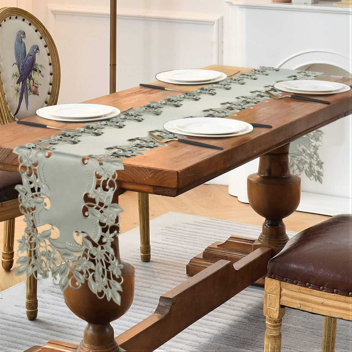 a wooden dining table with a decorative table runner, two chairs, and a white tablecloth.