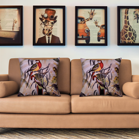 a beige sofa with two decorative throw pillows, each with a unique bird design. Above the sofa, there are four framed pictures on the wall, depicting various animals and scenes.
