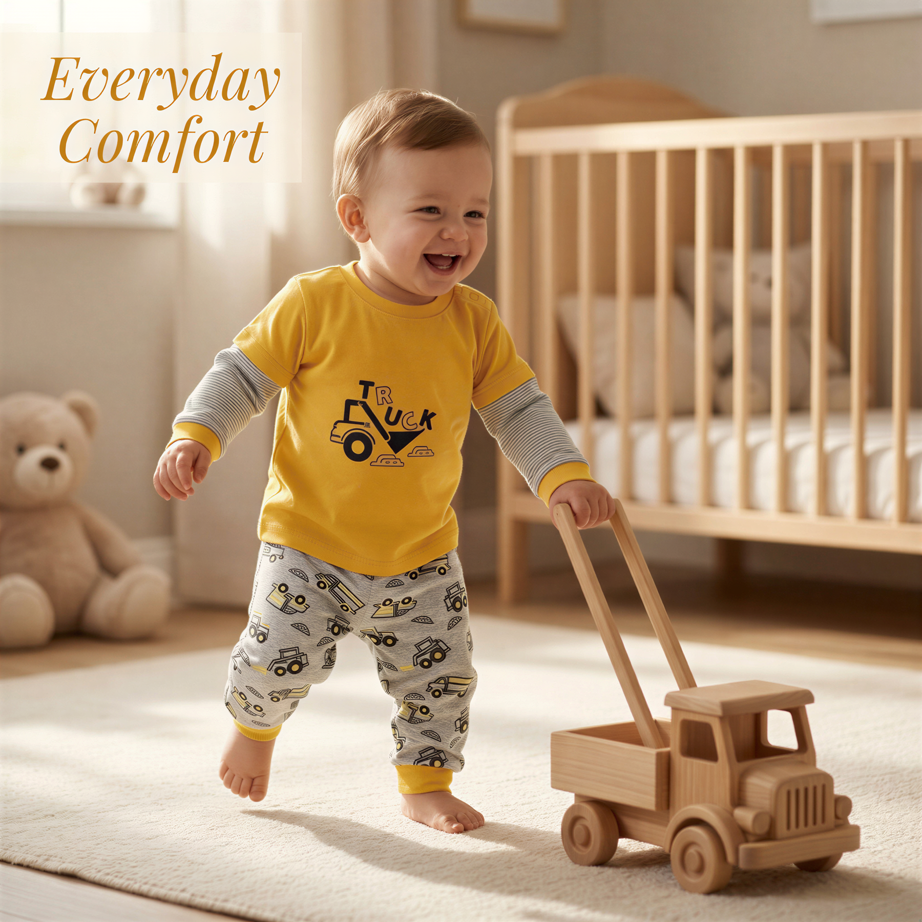 A smiling baby boy in a yellow shirt and patterned pants is holding a wooden toy truck in a nursery setting.