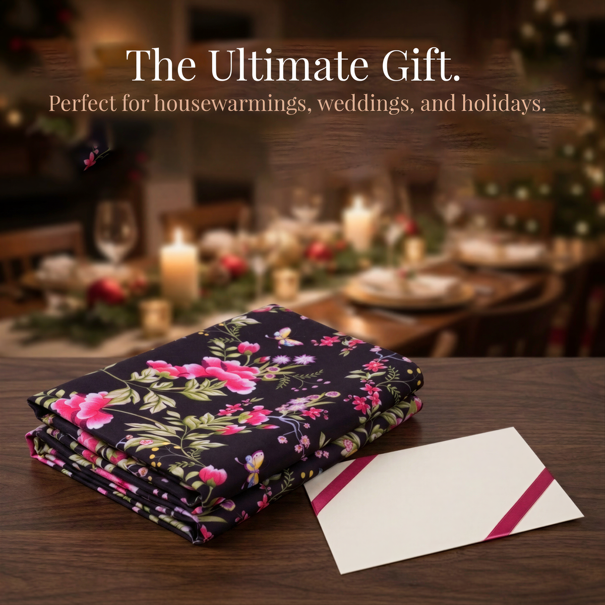 a floral print fabric, a white envelope with a red ribbon, and a blurred background of a dining table with a Christmas tree.