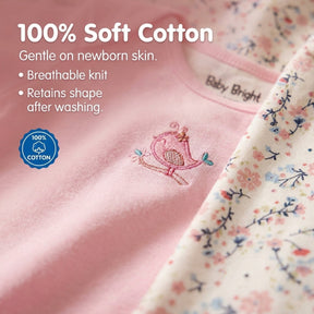 a close-up of a soft cotton fabric, with a pink floral print on the right side. The text on the fabric indicates that it is 100% cotton, which is gentle on newborn skin, breathable, and retains its shape after washing.