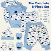 a complete set of baby clothing and accessories, including a blue bodysuit, hat, mittens, booties, and pants, all featuring a whale print pattern.