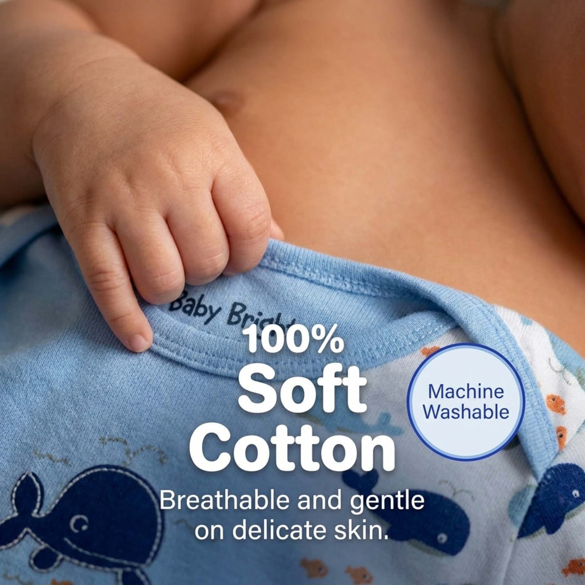 A close-up image of a baby's hand and arm wearing a blue baby onesie, with text highlighting the 100% soft cotton material and machine washable quality.