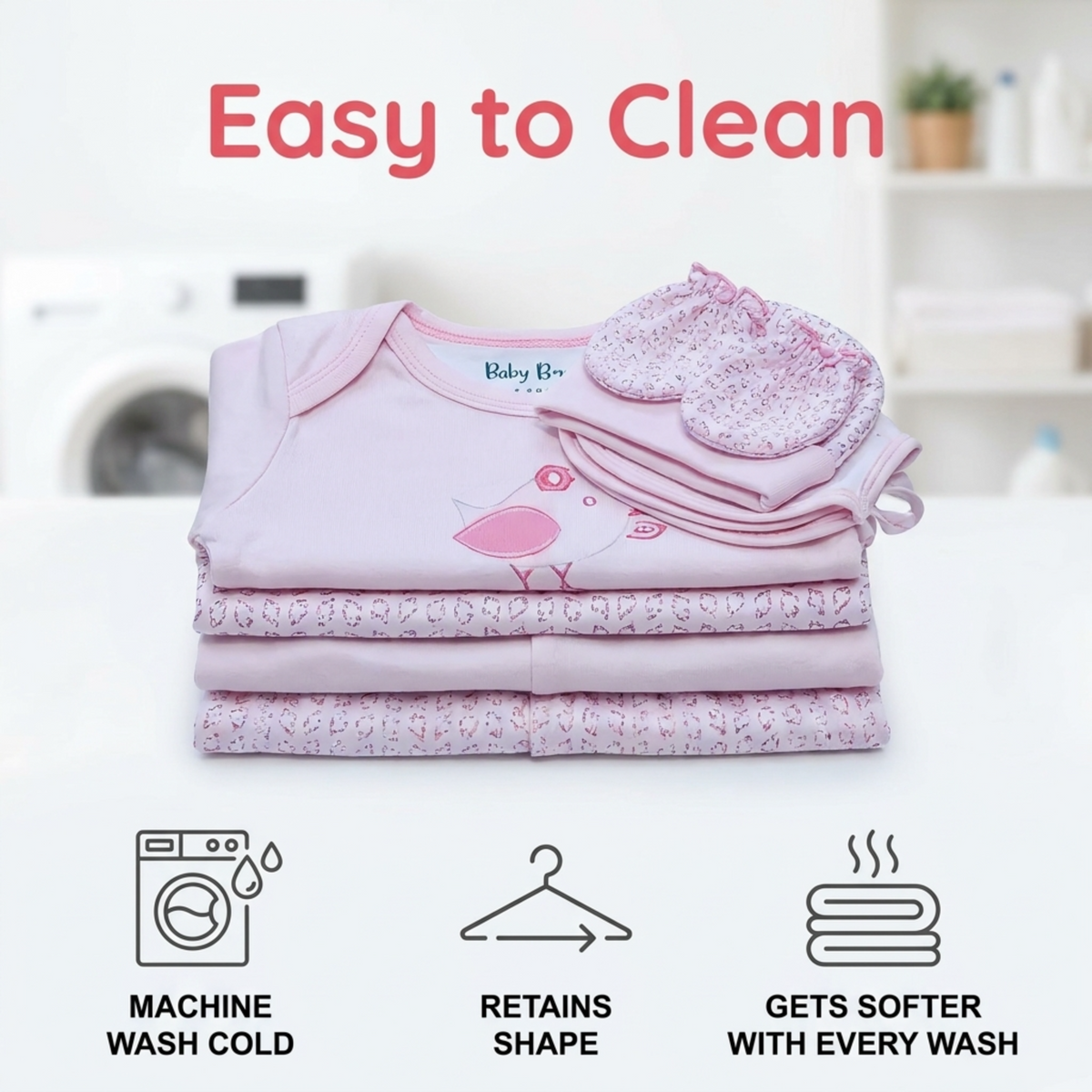 The image is an advertisement for baby clothing, featuring a stack of pink baby clothes and a baby mitten. The text highlights the ease of cleaning, retaining shape, and getting softer with every wash.