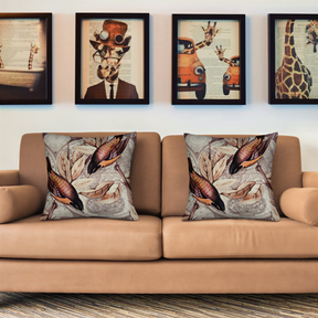 a beige sofa with two decorative throw pillows, each with a unique design. Above the sofa, there are four framed pictures on the wall, depicting various animals and objects.
