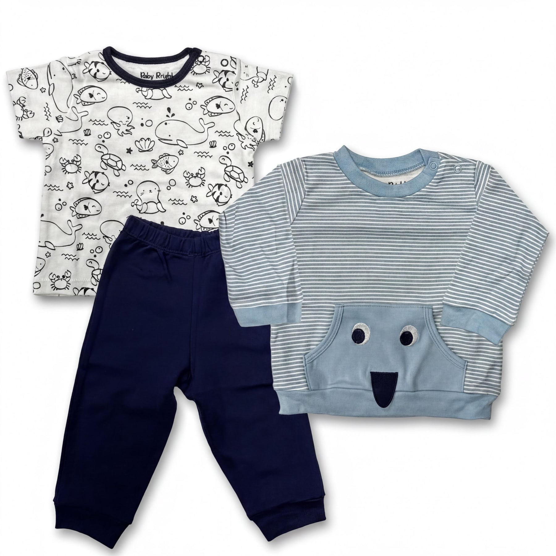 a collection of baby clothing items, including a white t-shirt with a black and white ocean print, navy blue pants, and a light blue striped shirt with a face design.