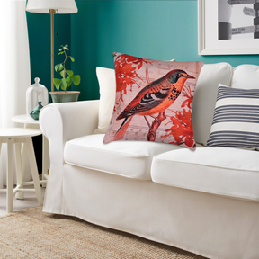 a living room with a white sofa, a decorative pillow with a bird design, and a small table with a lamp and a plant.