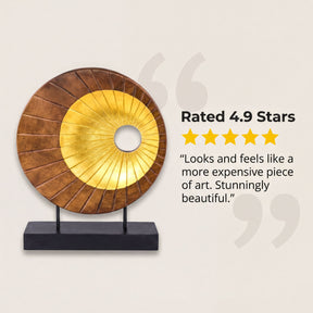 a decorative piece with a golden circular design, mounted on a black base and displayed on a white background.