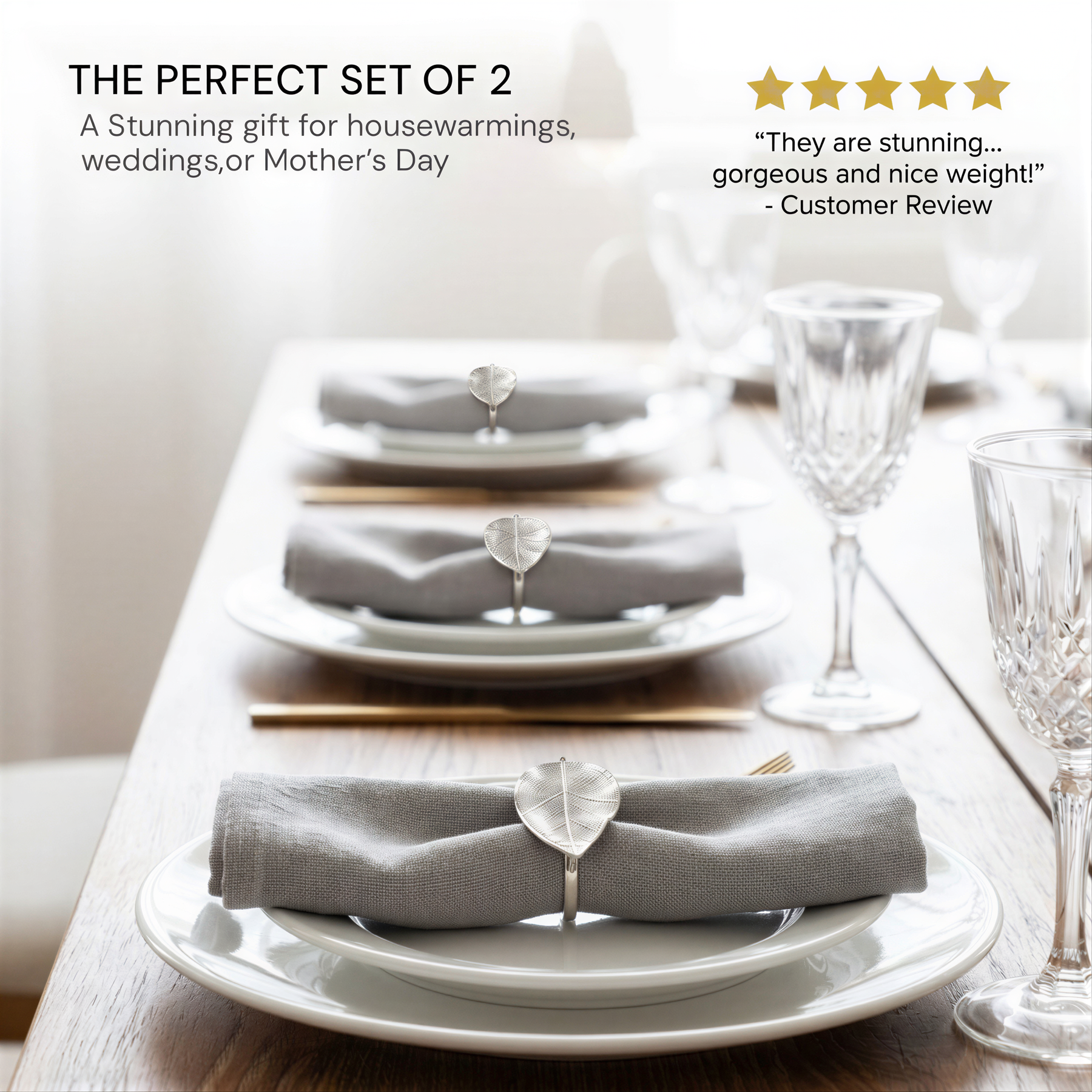 a set of three white plates with gray napkins, each set with a silver leaf-shaped napkin ring. The plates are arranged on a wooden table, and there are wine glasses and a chair visible in the background.