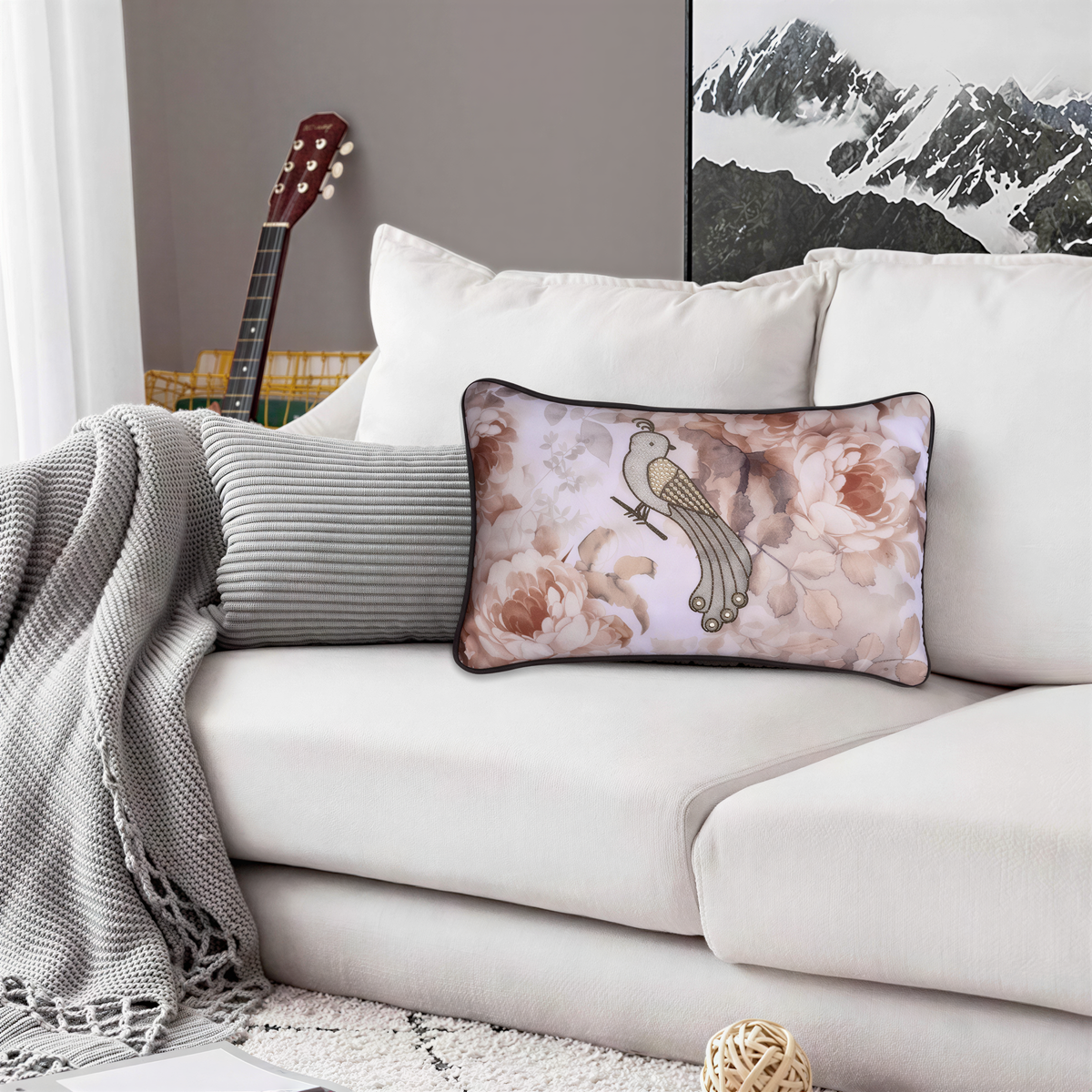 a cozy living room with a white couch adorned with a floral pillow and a gray blanket. In the background, there is a guitar and a mountain landscape, creating a harmonious and inviting atmosphere.