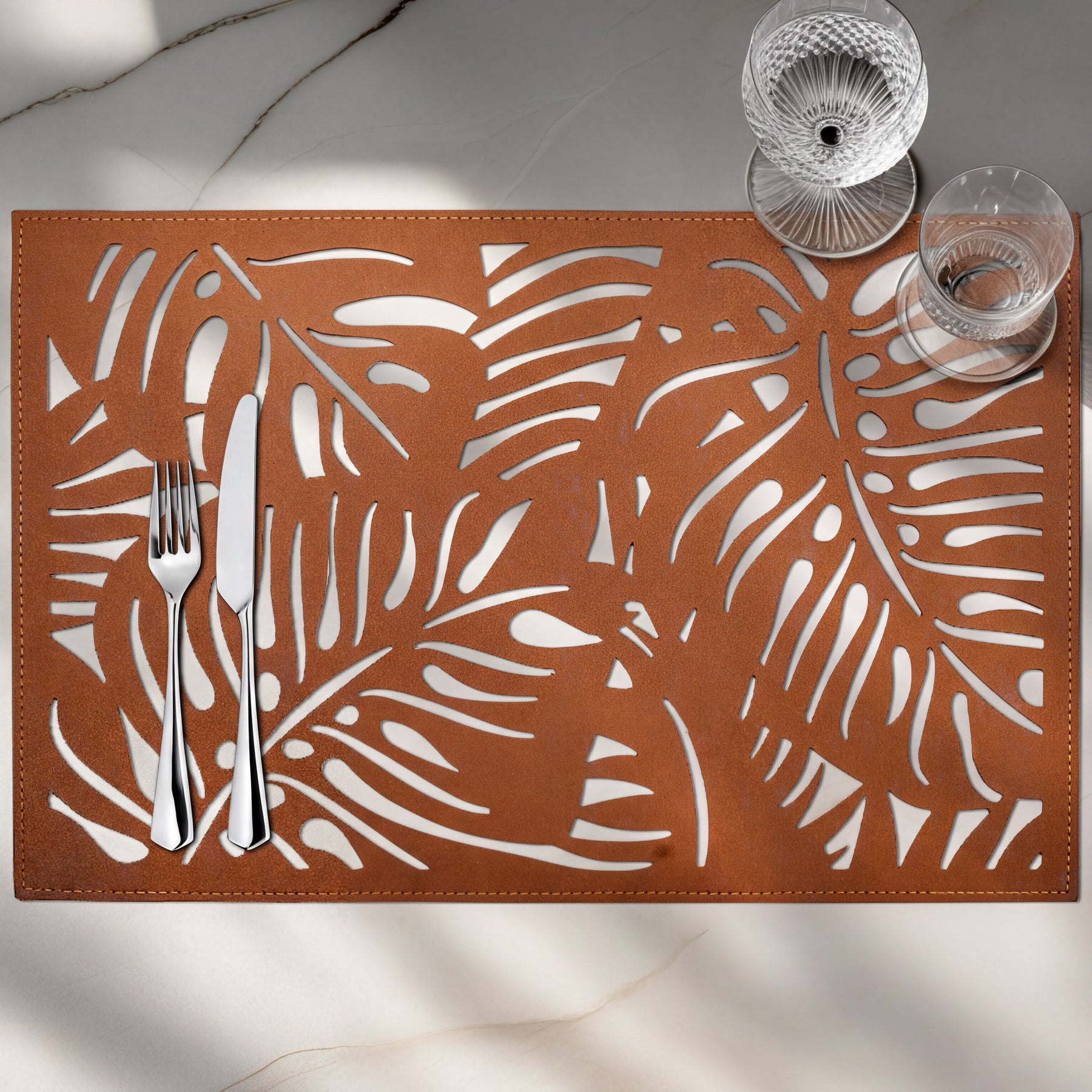 Set of six Monstera leaf cut out leather placemats by ACM1247-BRN, featuring tropical leaf designs for stylish table setting.