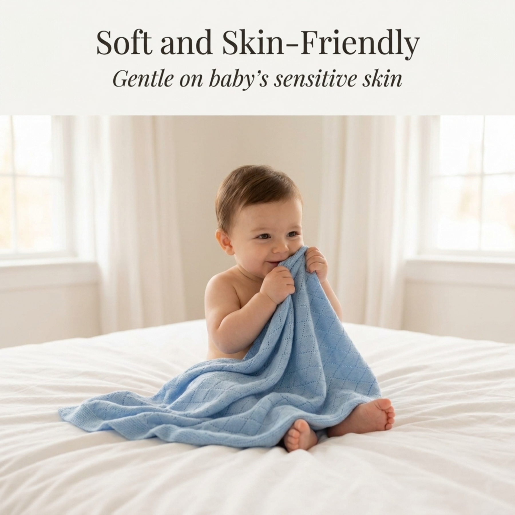 A smiling baby wrapped in a soft blue blanket sits on a bed, looking content and comfortable.