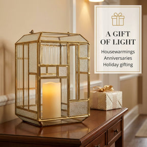 Gold metal frame and glass candle holder lantern, decorative candle lantern with intricate design for ambient lighting.