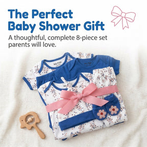a set of baby clothes and accessories, including a blue onesie, a pink bow, and a wooden baby rattle, arranged on a white background.