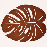 Set of six Monstera leaf cut out leather placemats by ACM1206-BRN, showcasing stylish, nature-inspired design on smooth leather.