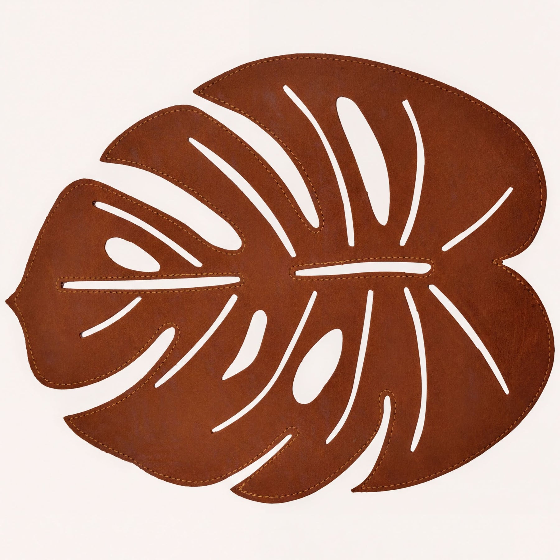 Set of six Monstera leaf cut out leather placemats by ACM1206-BRN, showcasing stylish, nature-inspired design on smooth leather.