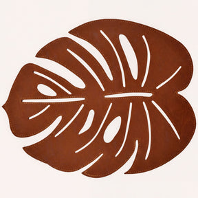 Set of six Monstera leaf cut out leather placemats by ACM1206-BRN, showcasing stylish, nature-inspired design on smooth leather.