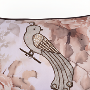 a close-up of a decorative bird embroidered on a fabric with a floral pattern.