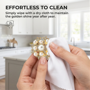 A person's hands holding a white cloth with a decorative piece of jewelry, possibly a brooch or pendant, and a text overlay providing instructions on how to clean the jewelry.