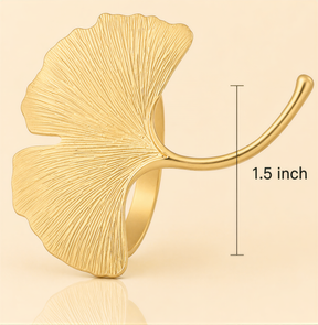 A gold ring with a leaf-shaped design, measuring 1.5 inches in length.