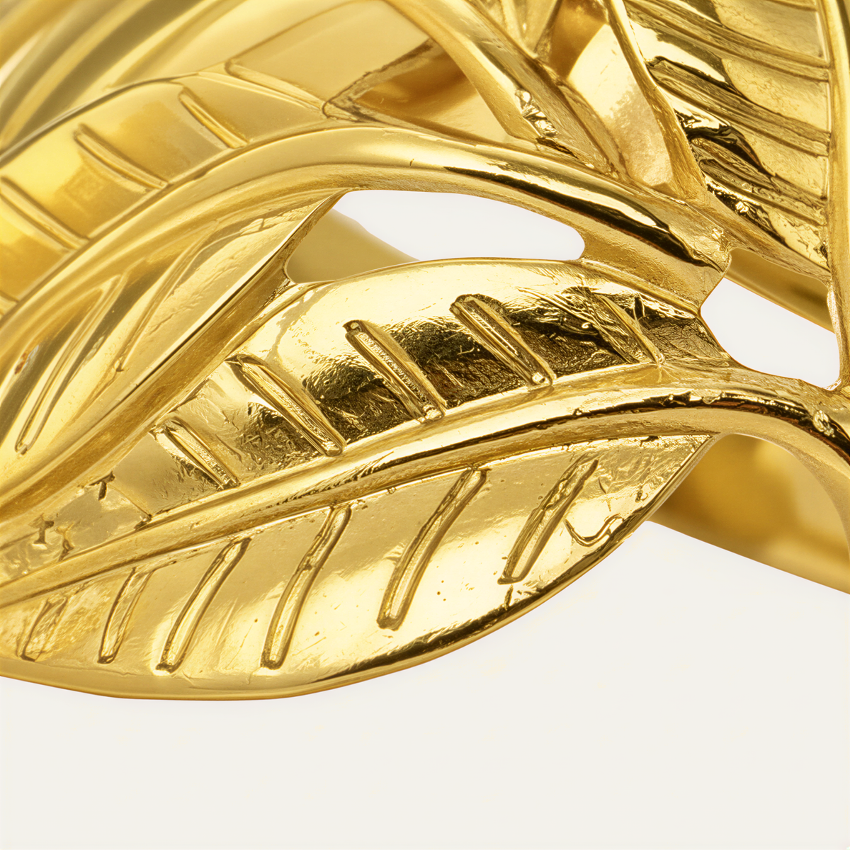 A close-up view of a shiny, golden leaf-shaped object, possibly a piece of jewelry or a decorative item.