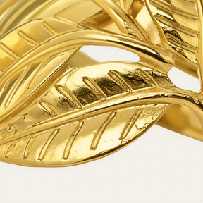 A close-up view of a shiny, golden leaf-shaped object, possibly a piece of jewelry or a decorative item.