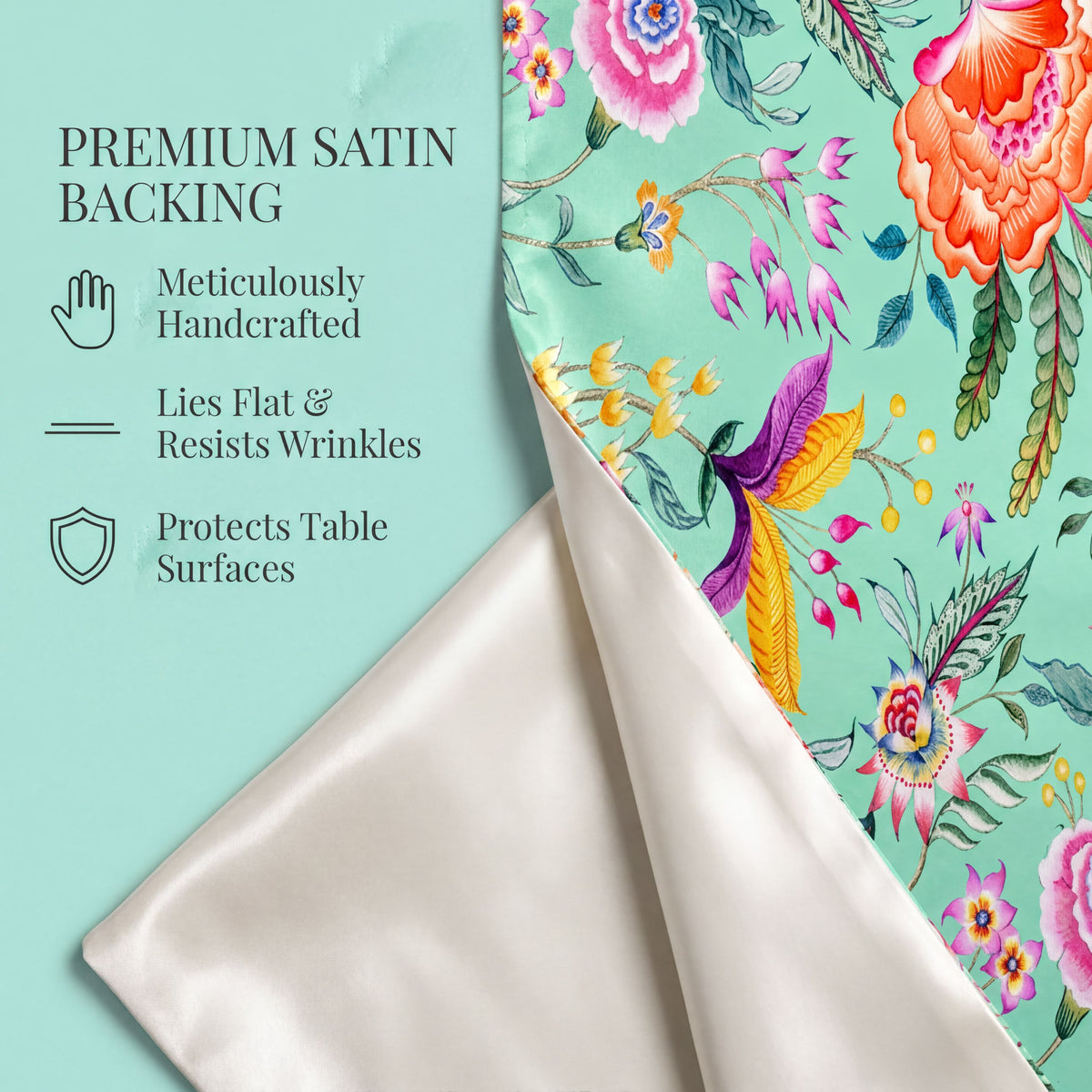 a vibrant floral pattern with pink, orange, and yellow flowers, along with green leaves, set against a light blue background. The text above the image reads "PREMIUM SATIN BACKING" and below it, there are descriptions of the backing material: "Metically Handcrafted", "Lies Flat & Resists Wrinkles", and "Protects Table Surfaces".