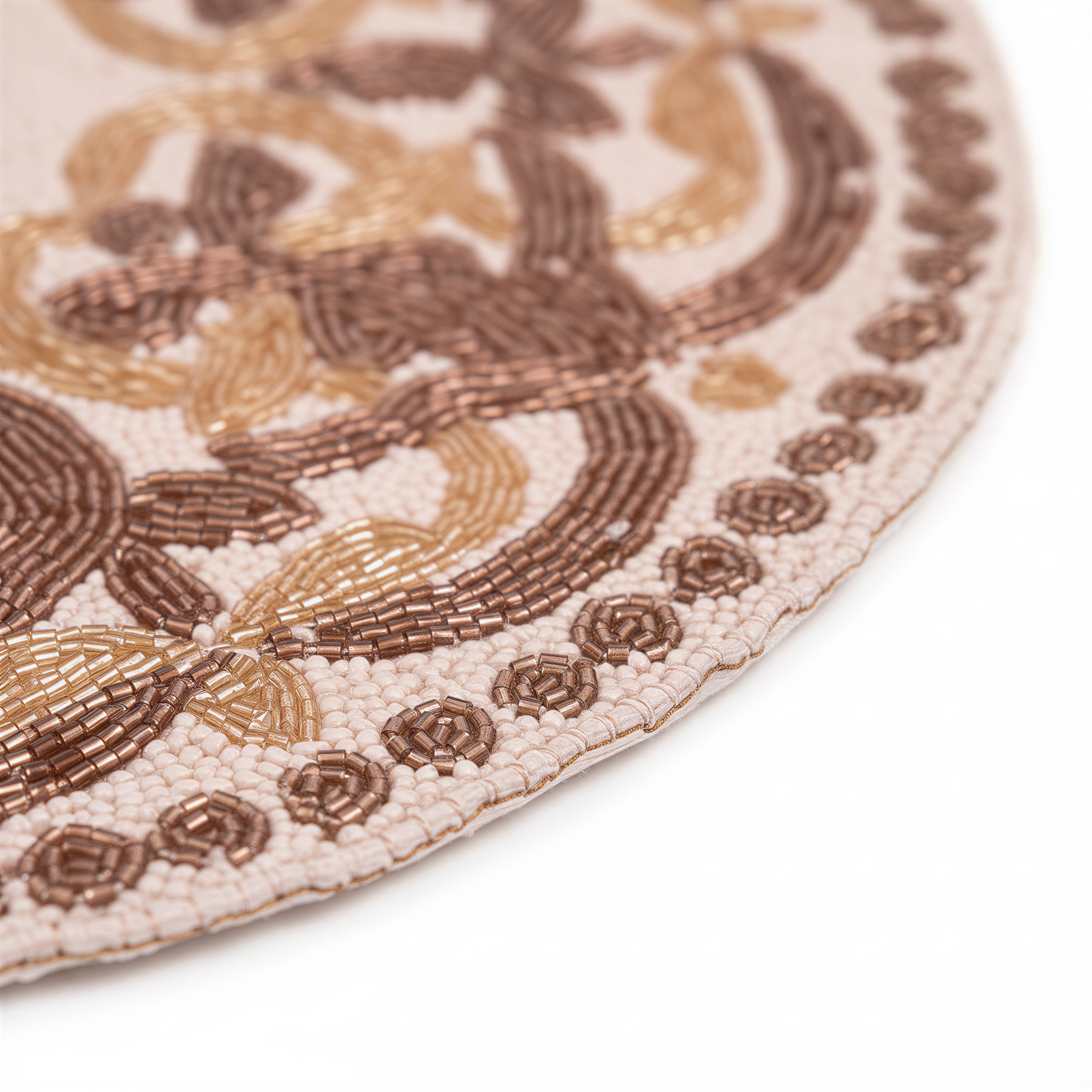 A close-up view of a decorative beaded design on a surface, featuring a repeating pattern of brown and gold beads arranged in a circular pattern.