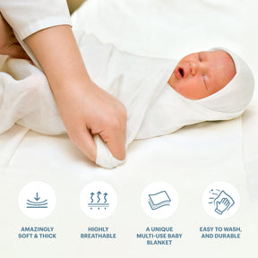 a person wrapping a baby in a soft and thick white blanket.