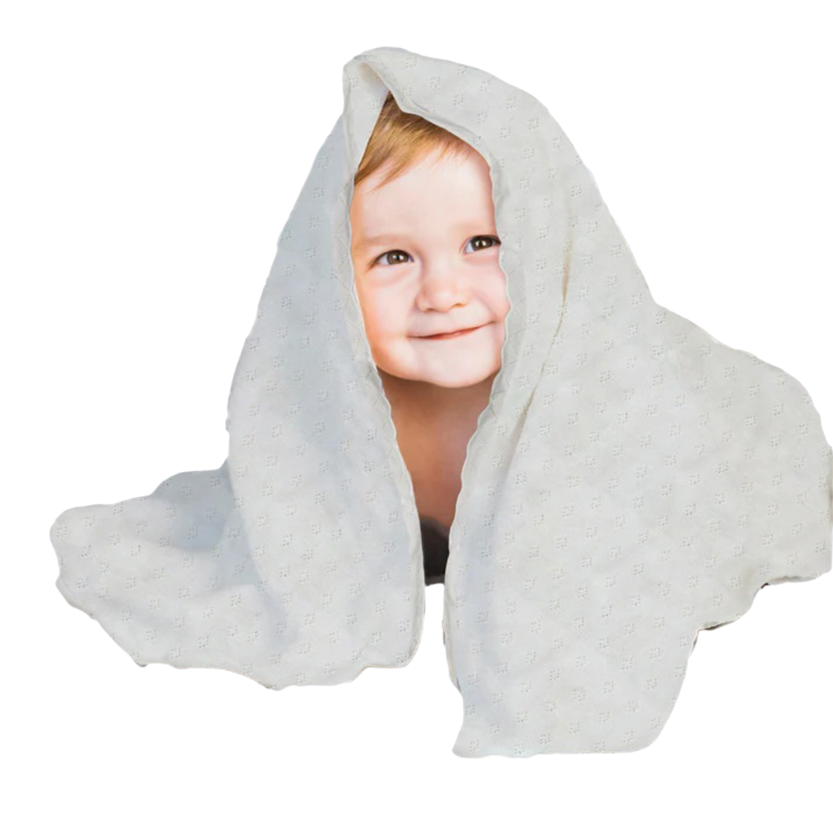 A young child with a smile on their face is peeking out from behind a white, polka-dotted blanket.