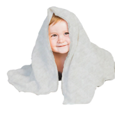 A young child with a smile on their face is peeking out from behind a white, polka-dotted blanket.