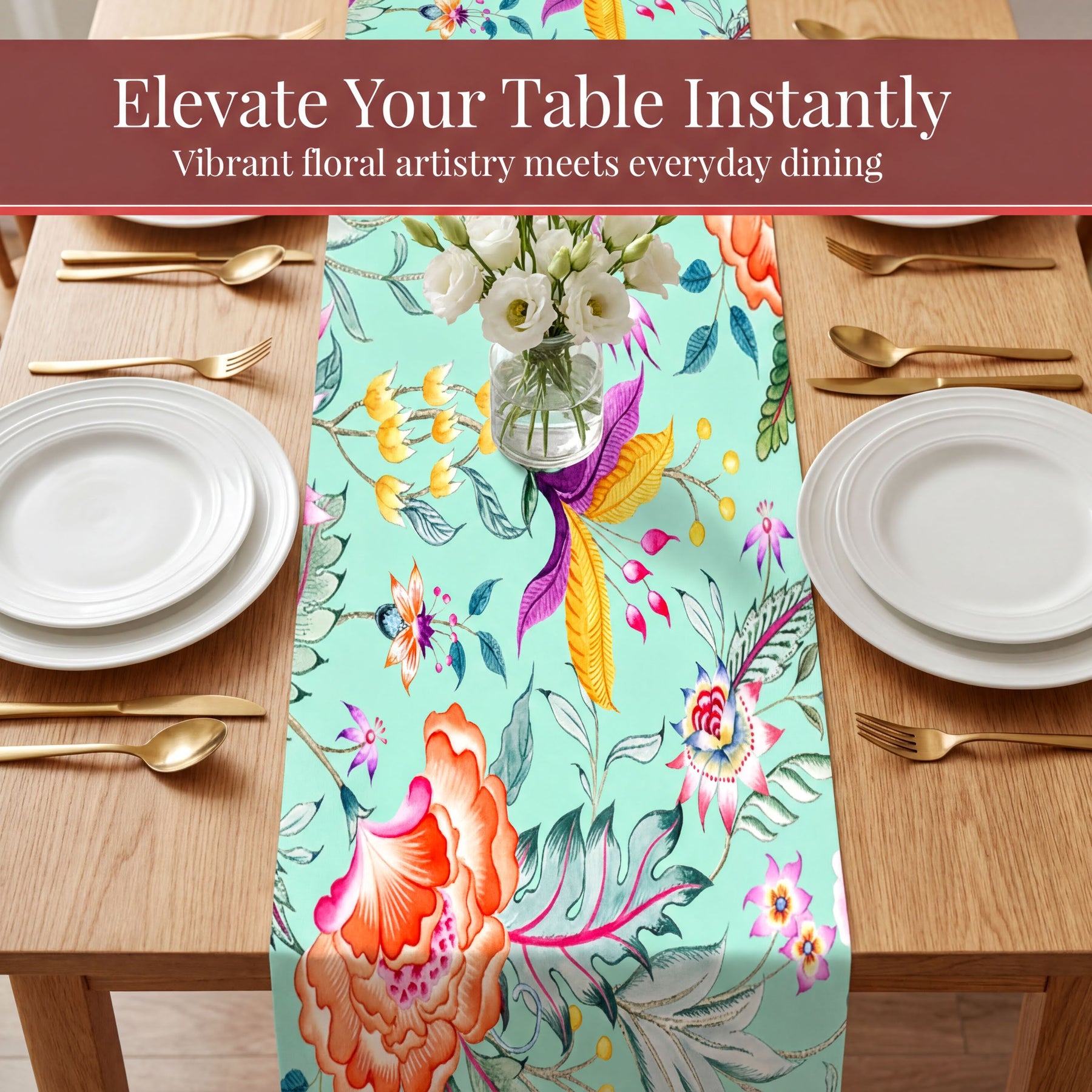 a table setting with a floral table runner, white plates, and gold cutlery.