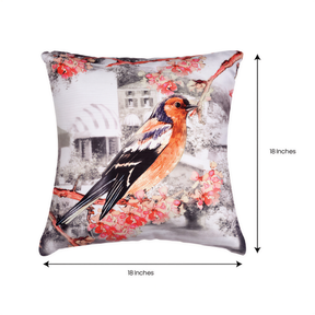 A decorative throw pillow with a colorful bird perched on a branch, surrounded by pink flowers.