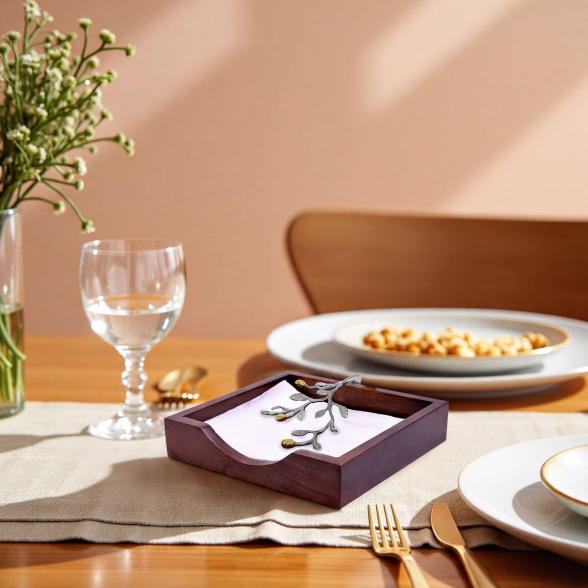 Solid wood napkin holder with silver and gold finish ornament, elegant countertop accessory for dining and entertaining.