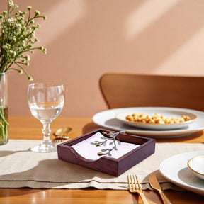 Solid wood napkin holder with silver and gold finish ornament, elegant countertop accessory for dining and entertaining.