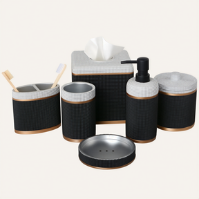 A set of black and white bathroom accessories, including a tissue box, soap dispenser, toothbrush holder, and other small containers.