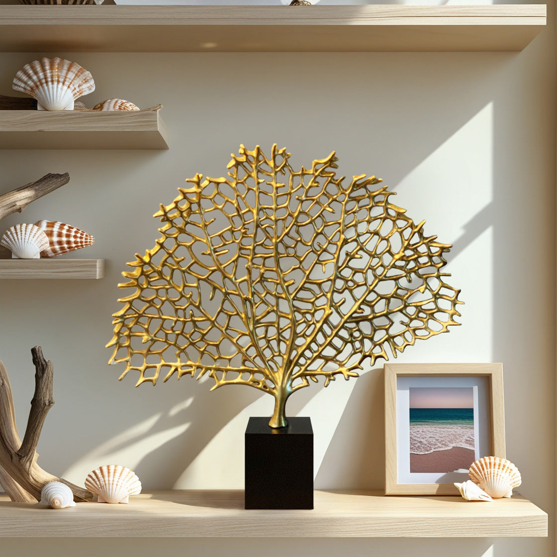 a decorative shelf with various items, including a large golden sculpture resembling a tree, seashells, and a framed photograph of a beach scene.