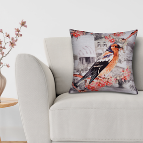 A white sofa with a decorative throw pillow featuring a colorful bird image.