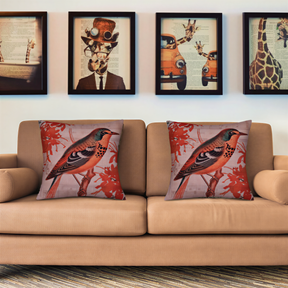 a beige sofa with two decorative throw pillows, each depicting a bird. Above the sofa, there are four framed pictures on the wall, including one of a giraffe, another of a car, and two other images that are not clearly visible.