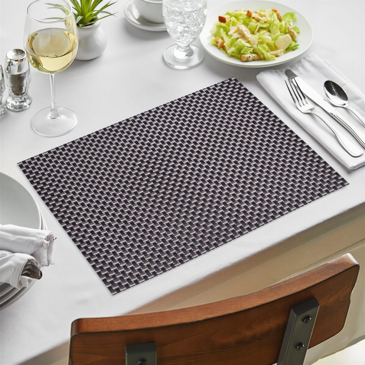 Black and gold PVC placemats with a decorative design, heat-resistant, washable, and wipeable for indoor and outdoor dining.