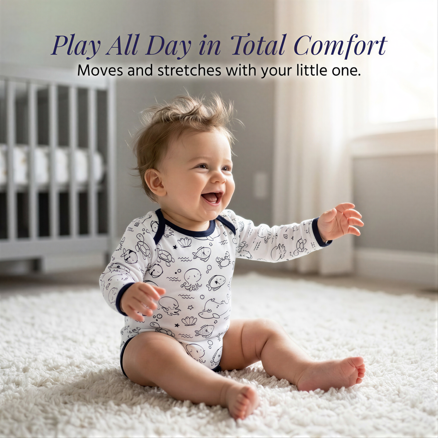 A smiling baby in a white onesie with black designs sits on a white carpet, with a crib visible in the background.